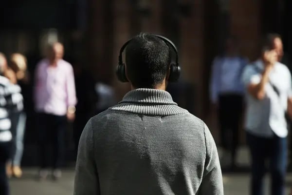 Un peatón utiliza unos auriculares en el distrito central de negocios de Sídney, Australia, el viernes 30 de abril de 2021.