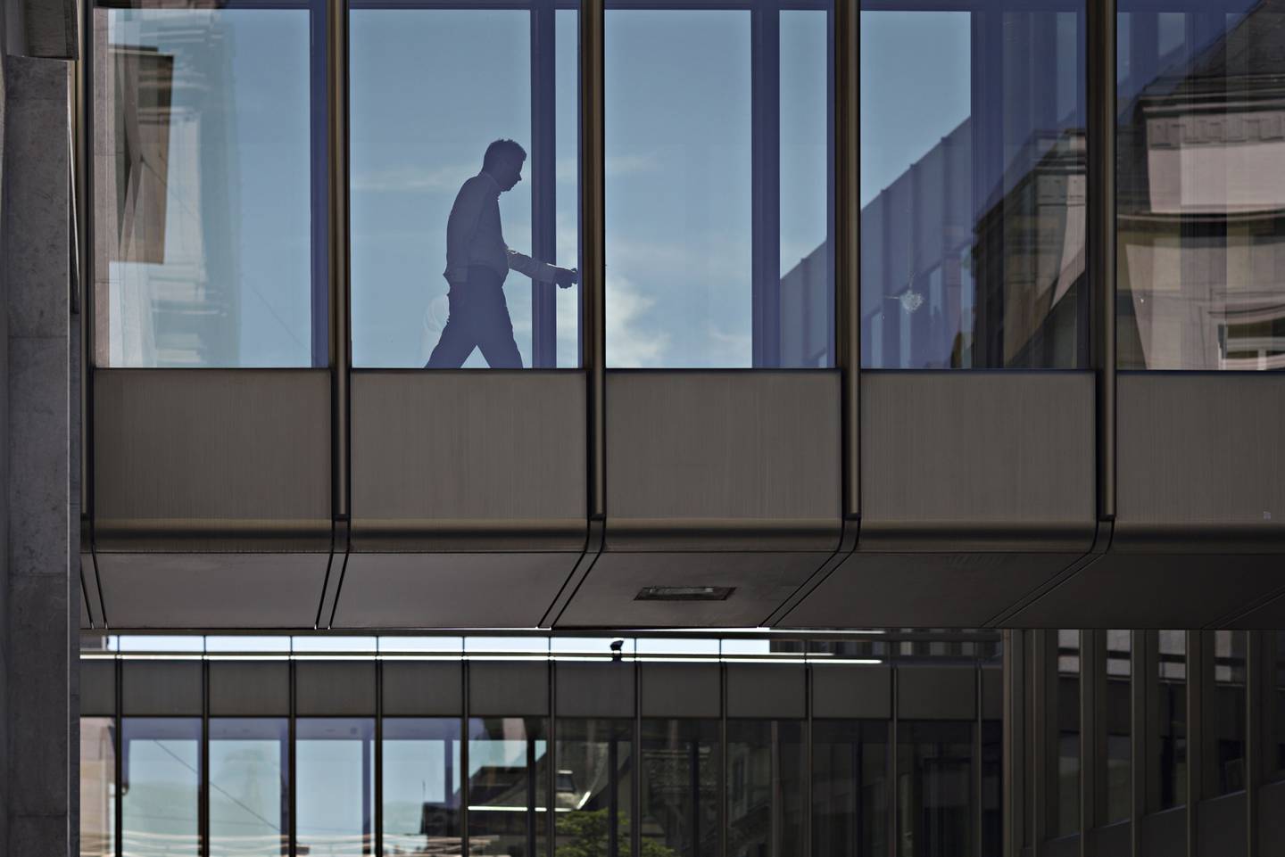A worker walks across a bridge inside a UBS Group AG office building in Zurich, Switzerland.