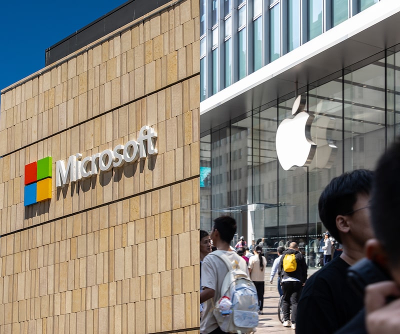 Fachada de un edificio de Microsoft y entrada de una tienda Apple, con sus respectivos logotipos. Fachada de un edificio de Microsoft y entrada de una tienda Apple, con sus respectivos logotipos.