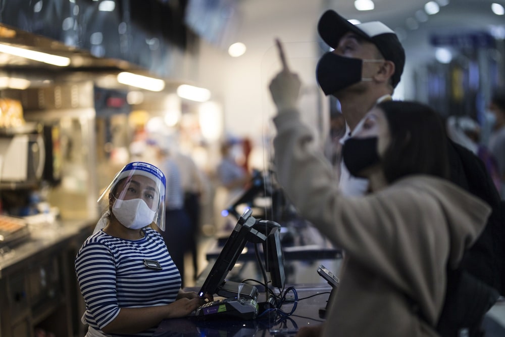 Personas con máscaras protectoras compran en una sala de Cine Colombia en Bogotá, Colombia, el martes 15 de junio de 2021. Personas con máscaras protectoras compran en una sala de Cine Colombia en Bogotá, Colombia, el martes 15 de junio de 2021.