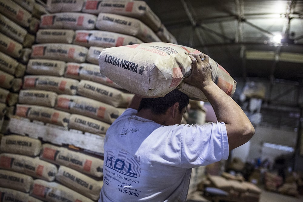 Un trabajador transporta un saco de cemento de Loma Negra Cía. Industrial Argentina S.A. en un almacén de Buenos Aires, Argentina, el jueves 26 de octubre de 2017. Un trabajador transporta un saco de cemento de Loma Negra Cía. Industrial Argentina S.A. en un almacén de Buenos Aires, Argentina, el jueves 26 de octubre de 2017.
