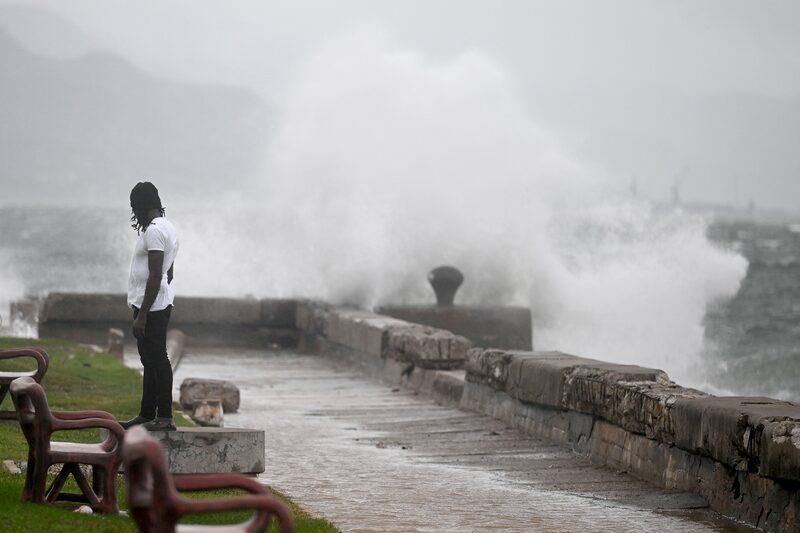 A man watches the waves crash into the walls at the Kingston Waterfront on October 27, 2025. A man watches the waves crash into the walls at the Kingston Waterfront on October 27, 2025.