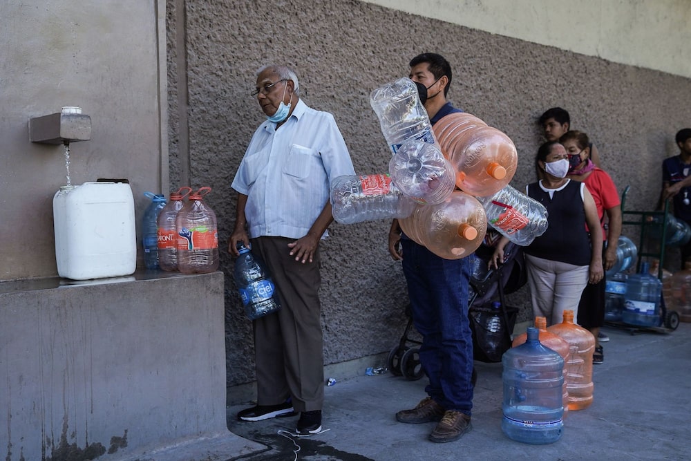 Residentes esperan en fila para llenar contenedores con agua limpia durante la escasez en Monterrey, estado de Nuevo León, México, el lunes 20 de junio de 2022. Residentes esperan en fila para llenar contenedores con agua limpia durante la escasez en Monterrey, estado de Nuevo León, México, el lunes 20 de junio de 2022.