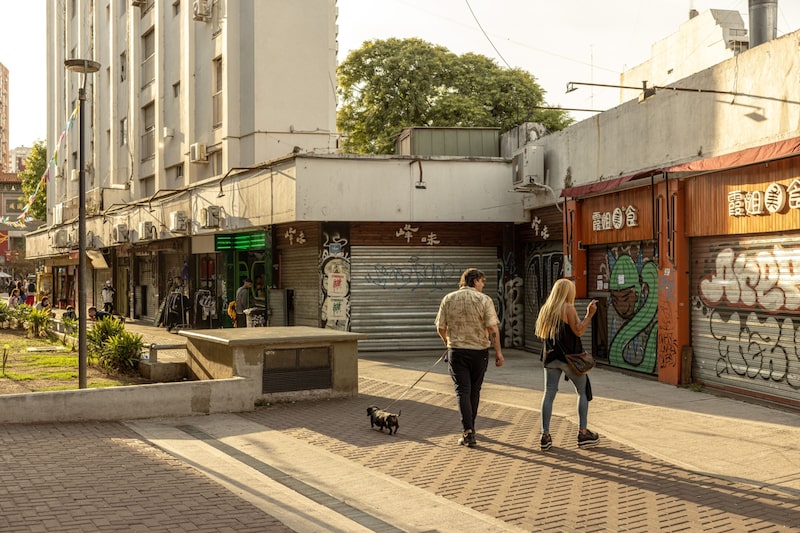 Pedestrians walk past shuttered stores in the Belgrano neighborhood of Buenos Aires. Pedestrians walk past shuttered stores in the Belgrano neighborhood of Buenos Aires.