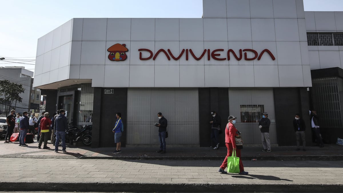 Personas hacen fila frente a un banco en Bogotá, Colombia.