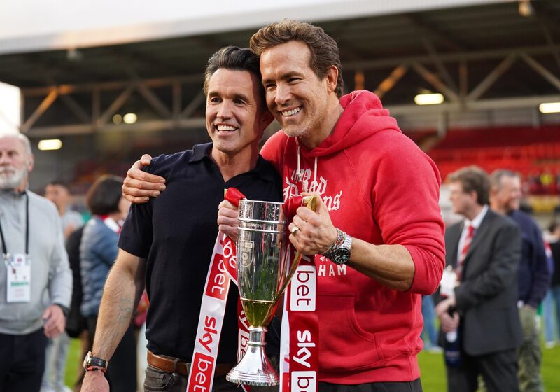 Ryan Reynolds (à direita) e Rob McElhenney com o troféu pelo vice-campeonato na terceira divisão do futebol inglês na última temporada Ryan Reynolds (à direita) e Rob McElhenney com o troféu pelo vice-campeonato na terceira divisão do futebol inglês na última temporada