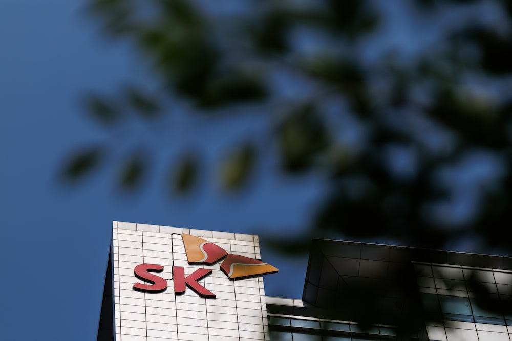 The SK Group logo is displayed atop the SK Hynix Inc. office building in Seongnam, South Korea, on Tuesday, June 30, 2026. South Korean firms including Samsung and SK Hynix will spend at least 1,350 trillion won ($880 billion) on chips and data centers as the country seeks to maintain its edge in the AI era. Photographer: SeongJoon Cho/Bloomberg The SK Group logo is displayed atop the SK Hynix Inc. office building in Seongnam, South Korea, on Tuesday, June 30, 2026. South Korean firms including Samsung and SK Hynix will spend at least 1,350 trillion won ($880 billion) on chips and data centers as the country seeks to maintain its edge in the AI era. Photographer: SeongJoon Cho/Bloomberg