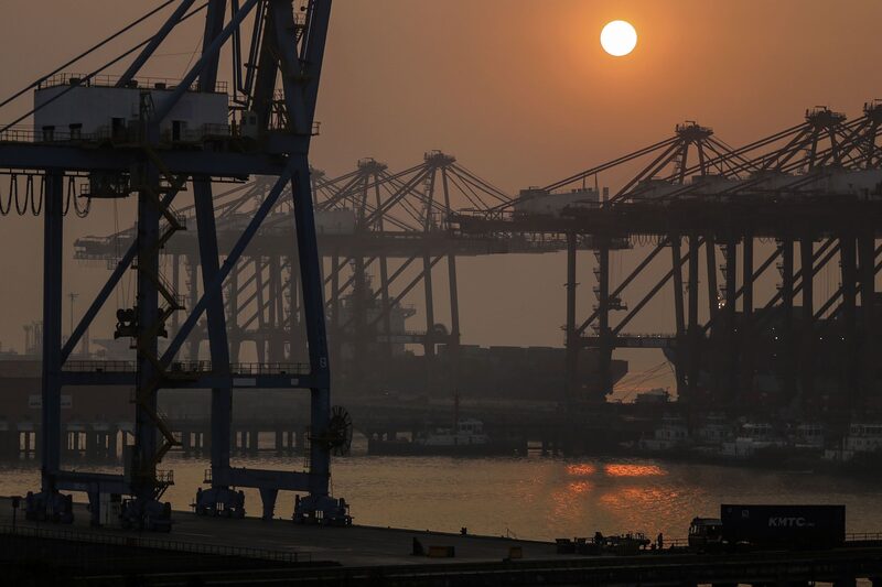 O sol se põe sobre guindastes de pórtico no porto de Jawaharlal Nehru, operado pela Jawaharlal Nehru Port Trust (JNPT), em Navi Mumbai O sol se põe sobre guindastes de pórtico no porto de Jawaharlal Nehru, operado pela Jawaharlal Nehru Port Trust (JNPT), em Navi Mumbai