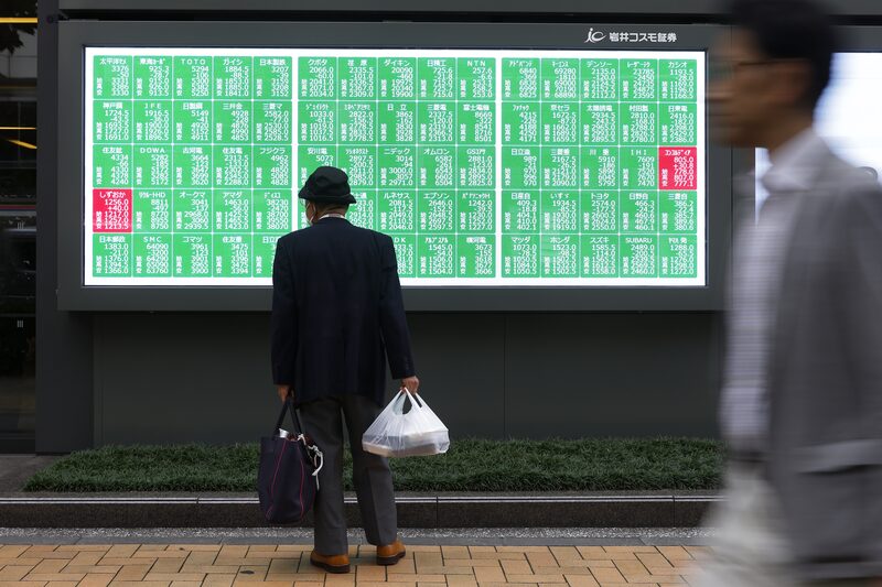 Un tablero electrónico de valores fuera de una empresa de valores en Tokio. Un tablero electrónico de valores fuera de una empresa de valores en Tokio.