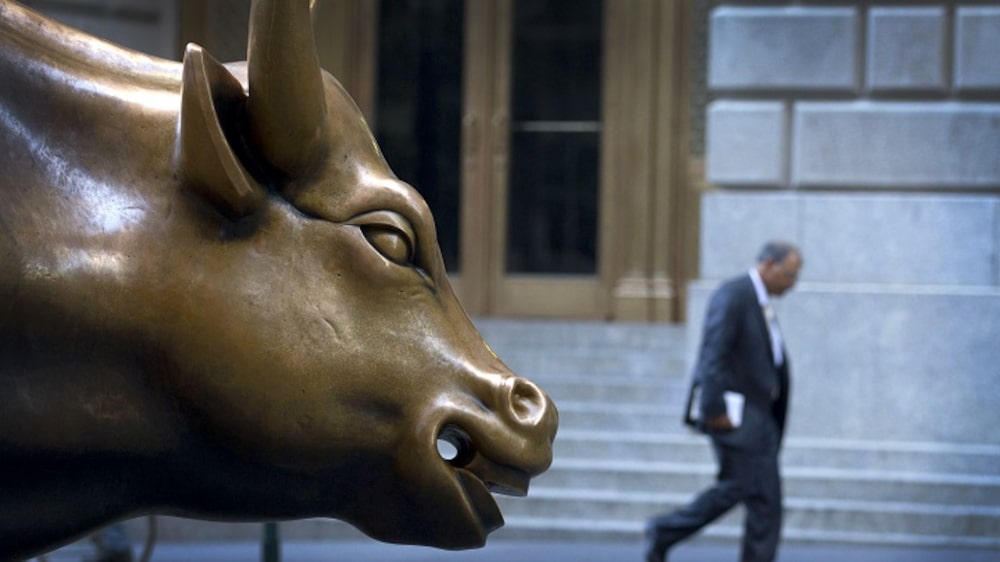 Un hombre pasa junto a la estatua del toro cerca de la Bolsa de Valores de Nueva York, en Nueva York. Un hombre pasa junto a la estatua del toro cerca de la Bolsa de Valores de Nueva York, en Nueva York.