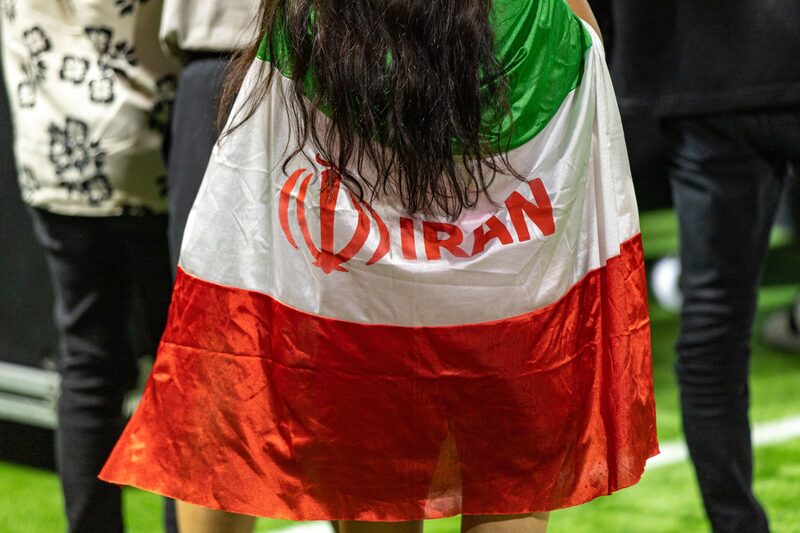 Un aficionado con una bandera iraní asiste al partido de la Copa Mundial de la FIFA 2022 entre Irán y Estados Unidos en el BudX FIFA Fan Festival. Un aficionado con una bandera iraní asiste al partido de la Copa Mundial de la FIFA 2022 entre Irán y Estados Unidos en el BudX FIFA Fan Festival.