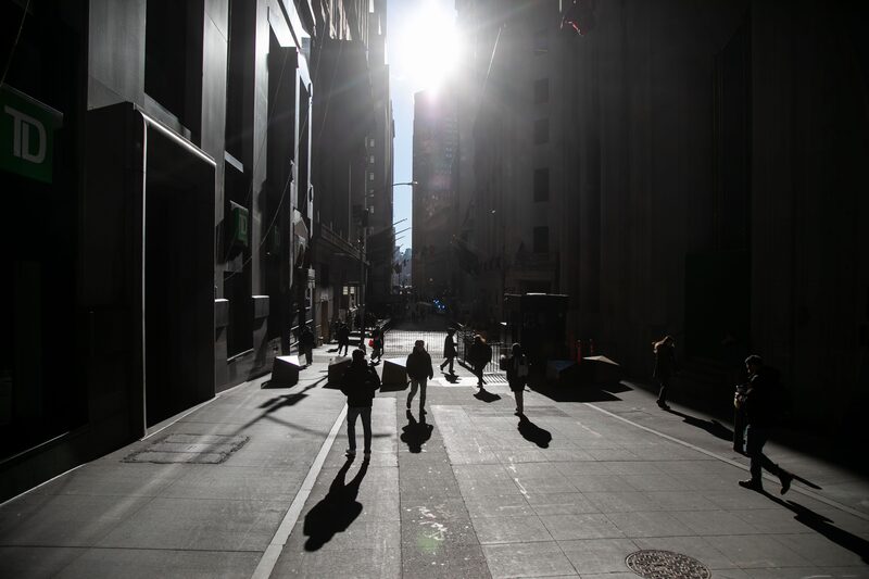 Pedestrians walk along Wall Street near the New York Stock Exchange. Pedestrians walk along Wall Street near the New York Stock Exchange.
