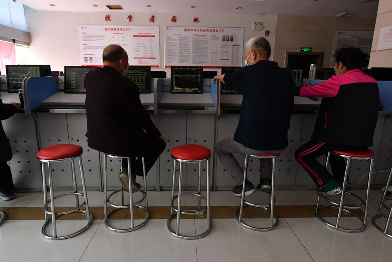 Inversores miran una pantalla con movimientos de acciones en China Inversores miran una pantalla con movimientos de acciones en China