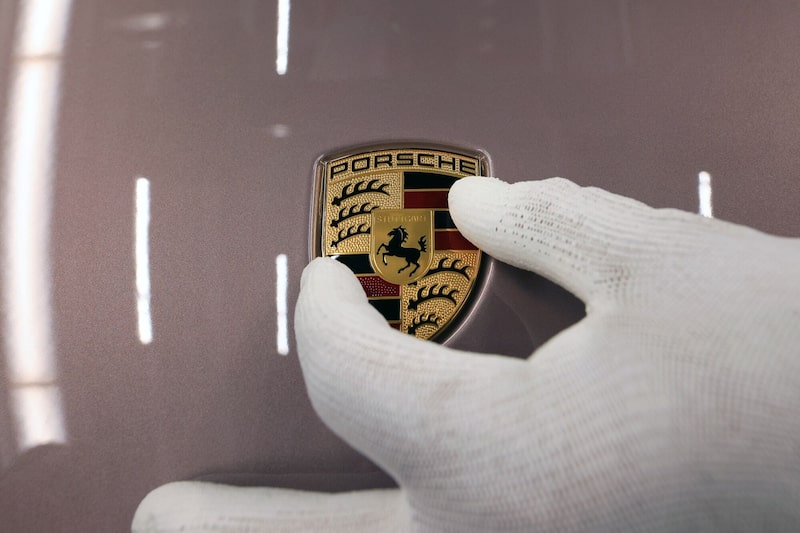 Un empleado coloca una insignia en el capó de un automóvil de lujo Porsche Taycan totalmente eléctrico en la línea de producción de la fábrica de Porsche AG en Stuttgart, Alemania, el lunes 26 de septiembre de 2022. Un empleado coloca una insignia en el capó de un automóvil de lujo Porsche Taycan totalmente eléctrico en la línea de producción de la fábrica de Porsche AG en Stuttgart, Alemania, el lunes 26 de septiembre de 2022.