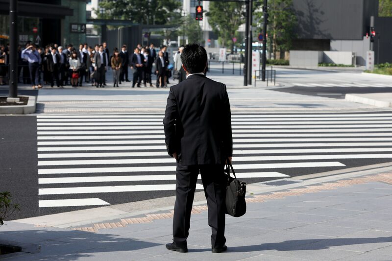 Un hombre espera para cruzar la calle en Tokyo. Un hombre espera para cruzar la calle en Tokyo.
