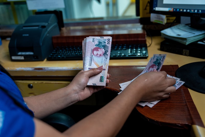 Un empleado de la oficina de remesas AirPak atiende a un cliente en Tegucigalpa, Honduras, el miércoles 13 de agosto de 2025. Un empleado de la oficina de remesas AirPak atiende a un cliente en Tegucigalpa, Honduras, el miércoles 13 de agosto de 2025.