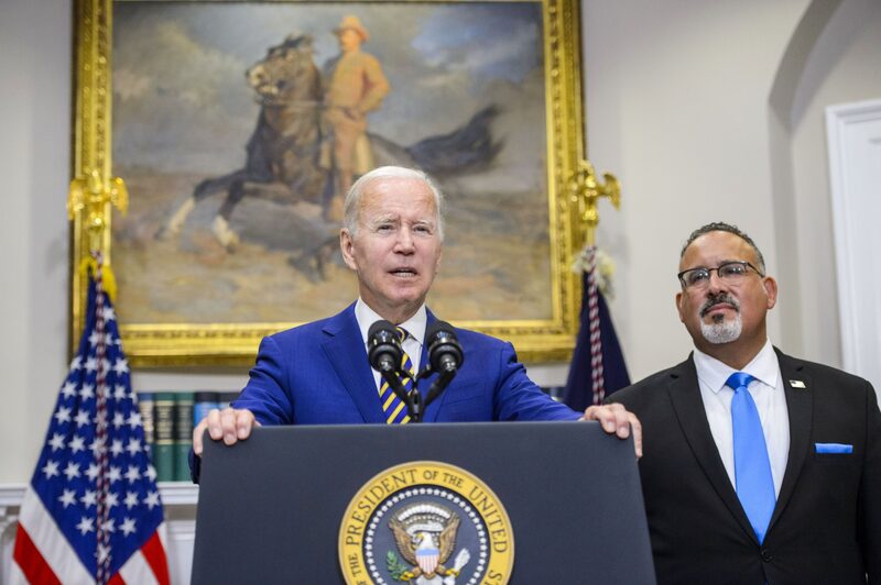 El presidente de EE.UU., Joe Biden, habla durante una conferencia de prensa con Miguel Cardona, secretario de Educación de EE.UU., a la derecha, en la Sala Roosevelt de la Casa Blanca en Washington, DC, EE.UU., el miércoles 24 de agosto de 2022. Biden anunció un amplio paquete de alivio de la deuda estudiantil que perdona hasta 20.000 dólares en préstamos para algunos beneficiarios, una medida que dijo ayudaría a una generación "cargada con una deuda insostenible." Fotógrafo: Bonnie Cash/UPI/Bloomberg El presidente de EE.UU., Joe Biden, habla durante una conferencia de prensa con Miguel Cardona, secretario de Educación de EE.UU., a la derecha, en la Sala Roosevelt de la Casa Blanca en Washington, DC, EE.UU., el miércoles 24 de agosto de 2022. Biden anunció un amplio paquete de alivio de la deuda estudiantil que perdona hasta 20.000 dólares en préstamos para algunos beneficiarios, una medida que dijo ayudaría a una generación "cargada con una deuda insostenible." Fotógrafo: Bonnie Cash/UPI/Bloomberg