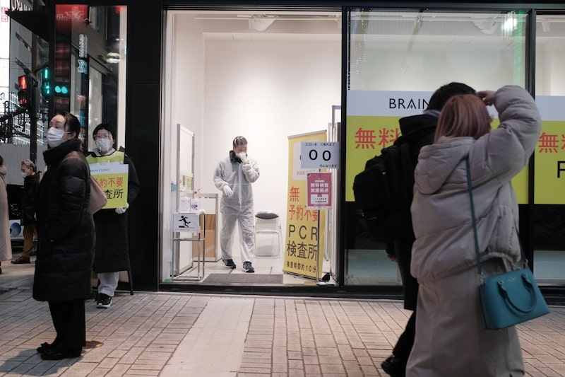 Pedestrians walk past a Covid-19 polymerase chain reaction (PCR) testing site in the Shinjuku district of Tokyo on Friday, Feb. 25, 2022. Japan is considering further easing Covid restrictions for those who are vaccinated, NHK reported. Pedestrians walk past a Covid-19 polymerase chain reaction (PCR) testing site in the Shinjuku district of Tokyo on Friday, Feb. 25, 2022. Japan is considering further easing Covid restrictions for those who are vaccinated, NHK reported.