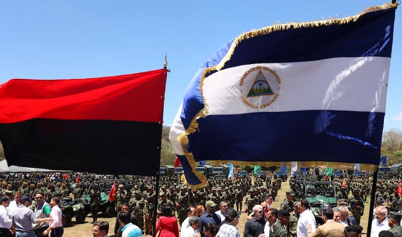La bandera nacional de Nicaragua, junto con la bandera del FSNL (declarada como símbolo patrio en una la última reforma constitucional) en un acto del Ejército, el 22 de marzo de 2025. La bandera nacional de Nicaragua, junto con la bandera del FSNL (declarada como símbolo patrio en una la última reforma constitucional) en un acto del Ejército, el 22 de marzo de 2025.