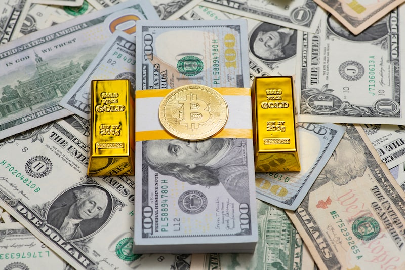 Monedas de bitcoin y otras criptomonedas junto a lingotes de oro. Foto: Shutterstock. Monedas de bitcoin y otras criptomonedas junto a lingotes de oro. Foto: Shutterstock.