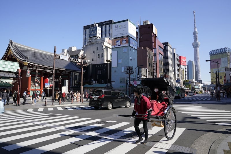 Un conductor de rickshaw transporta a un cliente frente al templo Sensoji, en el barrio de Asakusa, en Tokio. Un conductor de rickshaw transporta a un cliente frente al templo Sensoji, en el barrio de Asakusa, en Tokio.