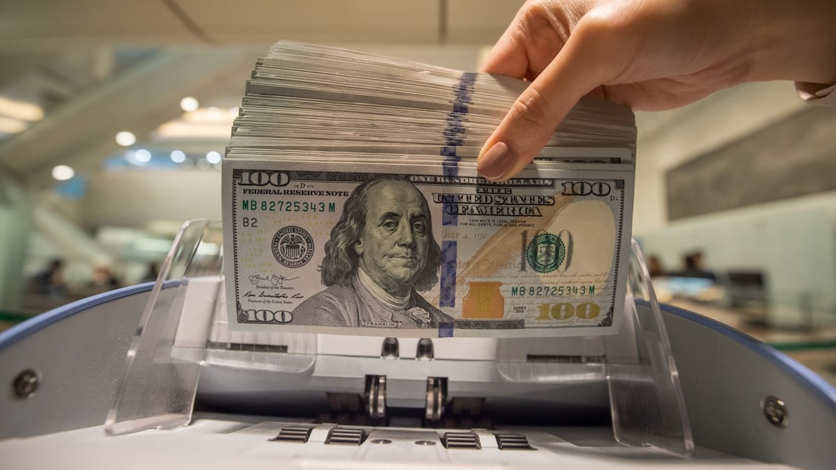 Un empleado utiliza una máquina para contar billetes de cien dólares estadounidenses en la sede de Hang Seng Bank Ltd. en Hong Kong, China.
