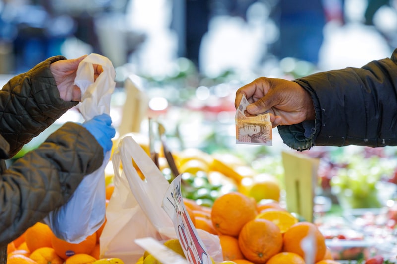 A shopper pays for groceries at a market stall selling fresh fruit and vegetables at Surrey Street market in Croydon, UK. Photographer: Jason Alden/Bloomberg A shopper pays for groceries at a market stall selling fresh fruit and vegetables at Surrey Street market in Croydon, UK. Photographer: Jason Alden/Bloomberg