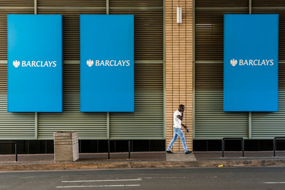 Un peatón pasa junto a grandes carteles de marca frente a las oficinas del banco Barclays Plc. Un peatón pasa junto a grandes carteles de marca frente a las oficinas del banco Barclays Plc.