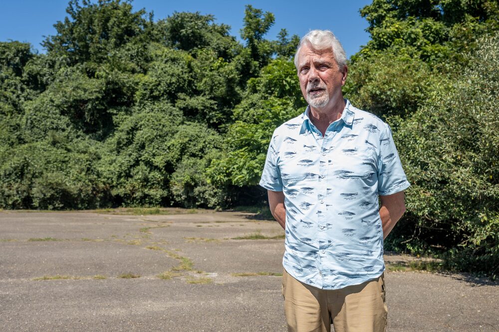 Homem grisalho em vestes de cor clara em frente a árvores Homem grisalho em vestes de cor clara em frente a árvores