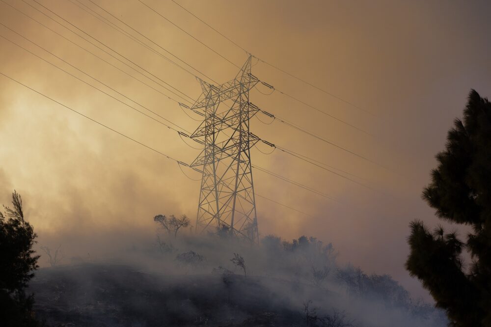 El humo se eleva por encima de un tendido eléctrico durante el incendio de Palisades en la zona de Mandeville Canyon, en Los Ángeles, el 11 de enero. Photographer: Benjamin Fanjoy/Bloomberg. El humo se eleva por encima de un tendido eléctrico durante el incendio de Palisades en la zona de Mandeville Canyon, en Los Ángeles, el 11 de enero. Photographer: Benjamin Fanjoy/Bloomberg.