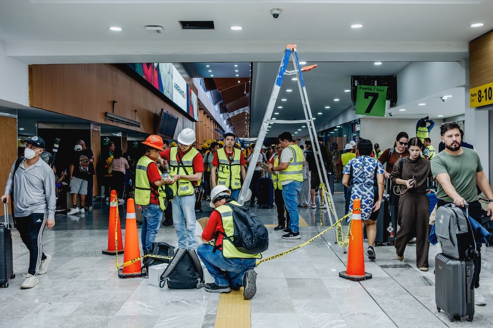 Viajantes desviam de operários que trabalham no conserto de um teto do aeroporto Benito Juárez (Foto: Fred Ramos/Bloomberg)
Viajantes desviam de operários que trabalham no conserto de um teto do aeroporto Benito Juárez (Foto: Fred Ramos/Bloomberg)