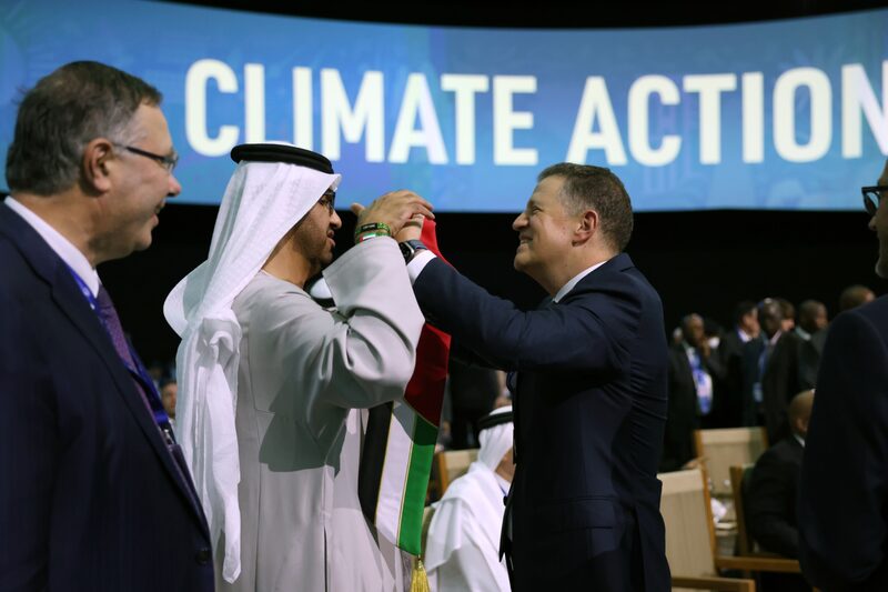 Majid Jafar, CEO de Crescent Petroleum Co., a la derecha, entrega a Sultan Ahmed Al Jaber, CEO de Abu Dhabi National Oil Co. (ADNOC) y presidente de la COP28, en el centro, un pañuelo con los colores de la bandera nacional de Emiratos Árabes Unidos durante la Cumbre sobre el Metano y Otros Gases de Efecto Invernadero distintos del CO2, el tercer día de la conferencia sobre el clima COP28, en la Expo City de Dubai, Emiratos Árabes Unidos, el sábado 2 de diciembre de 2023. Majid Jafar, CEO de Crescent Petroleum Co., a la derecha, entrega a Sultan Ahmed Al Jaber, CEO de Abu Dhabi National Oil Co. (ADNOC) y presidente de la COP28, en el centro, un pañuelo con los colores de la bandera nacional de Emiratos Árabes Unidos durante la Cumbre sobre el Metano y Otros Gases de Efecto Invernadero distintos del CO2, el tercer día de la conferencia sobre el clima COP28, en la Expo City de Dubai, Emiratos Árabes Unidos, el sábado 2 de diciembre de 2023.
