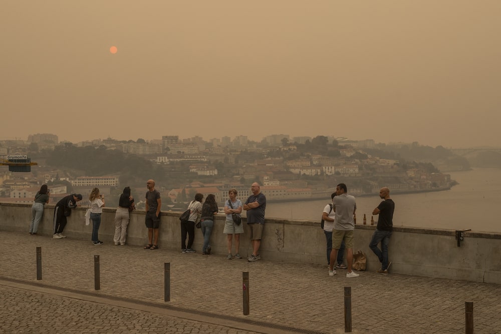La gente en el mirador Jardim do Morro observa como el humo de los incendios forestales envuelve la ciudad de Oporto, Portugal, el 18 de septiembre. Fotógrafo: Brais Lorenzo/Bloomberg La gente en el mirador Jardim do Morro observa como el humo de los incendios forestales envuelve la ciudad de Oporto, Portugal, el 18 de septiembre. Fotógrafo: Brais Lorenzo/Bloomberg