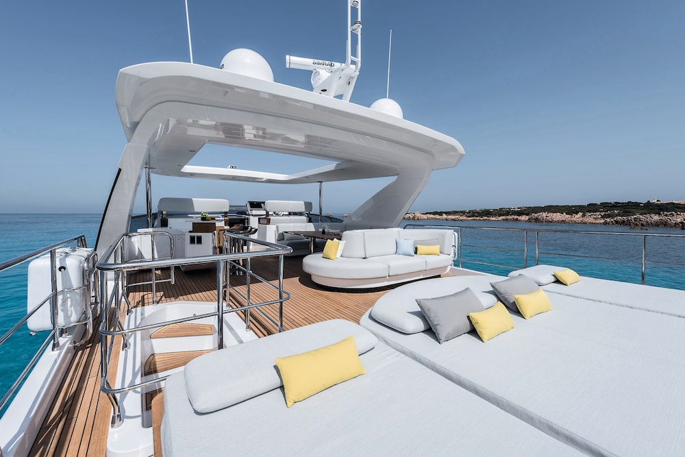 O deck superior de um iate da linha Grande, da Azimut, com radar e antenas de satélite Simrad visíveis no topo, ao lado de lounge e bar. O deck superior de um iate da linha Grande, da Azimut, com radar e antenas de satélite Simrad visíveis no topo, ao lado de lounge e bar.