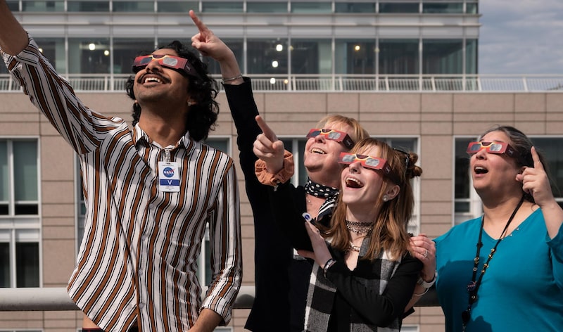 En la azotea de la sede de la NASA en Washington, varias personas siguen el eclipse solar total de abril de 2024. En la azotea de la sede de la NASA en Washington, varias personas siguen el eclipse solar total de abril de 2024.