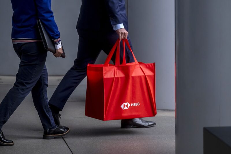 Un viajer que lleva una bolsa con el logotipo de HSBC Holdings Plc camina por debajo del edificio de la sede del banco en el distrito central de Hong Kong, China, el lunes 7 de junio de 2021. Un viajer que lleva una bolsa con el logotipo de HSBC Holdings Plc camina por debajo del edificio de la sede del banco en el distrito central de Hong Kong, China, el lunes 7 de junio de 2021.