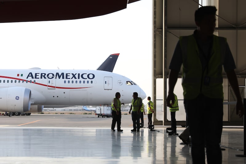 Un grupo de empleados de seguridad se encuentra cerca de un avión Boeing Dreamliner de Aeroméxico en el hangar de la compañía dentro del Aeropuerto Internacional Benito Juárez en la Ciudad de México, Un grupo de empleados de seguridad se encuentra cerca de un avión Boeing Dreamliner de Aeroméxico en el hangar de la compañía dentro del Aeropuerto Internacional Benito Juárez en la Ciudad de México,