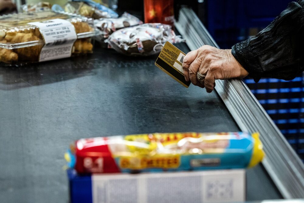 Consumidor pasa su tarjeta de crédito en un comercio. Consumidor pasa su tarjeta de crédito en un comercio.