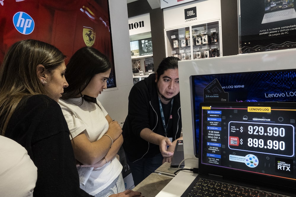 Três mulheres, das quais uma é vendedora, observam notebooks Três mulheres, das quais uma é vendedora, observam notebooks