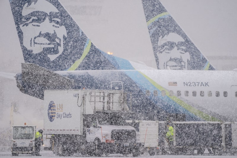 Trabajador junto a los aviones de Alaska Airlines durante una tormenta de nieve en el Aeropuerto Internacional de Seattle-Tacoma (SEA) en Seattle, Washington, EE.UU. Trabajador junto a los aviones de Alaska Airlines durante una tormenta de nieve en el Aeropuerto Internacional de Seattle-Tacoma (SEA) en Seattle, Washington, EE.UU.