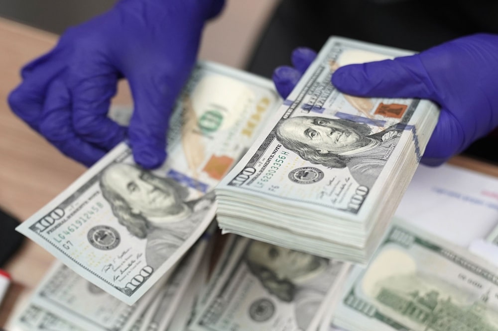 Una mujer cuenta un fajo de billetes de cien dólares estadounidenses en Indonesia. Una mujer cuenta un fajo de billetes de cien dólares estadounidenses en Indonesia.