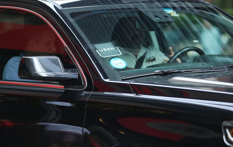 Foto do para brisas de um carro com o adesivo da Uber Foto do para brisas de um carro com o adesivo da Uber