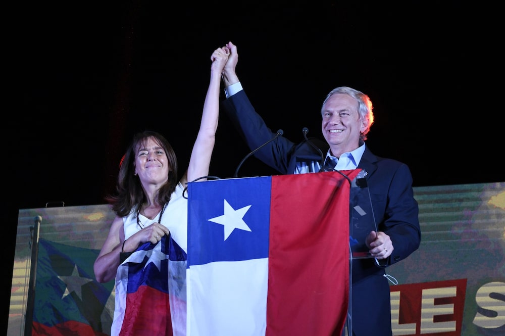 José Antonio Kast, en el escenario con su esposa María Pía Adriasola durante un mitin de la noche electoral en Santiago, Chile, el domingo 21 de noviembre de 2021. El candidato conservador a la presidencia de Chile, Kast, y su rival de izquierda, Gabriel Boric, se enfrentarán en una segunda vuelta el próximo mes, preparando el escenario para la elección más divisiva desde el retorno de la democracia en 1990. Fotógrafo: Tamara Merino/Bloomberg José Antonio Kast, en el escenario con su esposa María Pía Adriasola durante un mitin de la noche electoral en Santiago, Chile, el domingo 21 de noviembre de 2021. El candidato conservador a la presidencia de Chile, Kast, y su rival de izquierda, Gabriel Boric, se enfrentarán en una segunda vuelta el próximo mes, preparando el escenario para la elección más divisiva desde el retorno de la democracia en 1990. Fotógrafo: Tamara Merino/Bloomberg