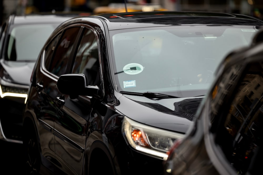 Carro de cor escura com adesivo da Uber Carro de cor escura com adesivo da Uber