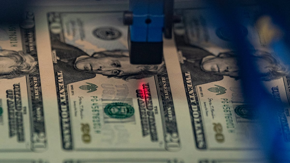 Un láser inspecciona una hoja de 50 billetes de 20 dólares tras la asignación de un número de serie en la Oficina de Grabado e Impresión de EE.UU.