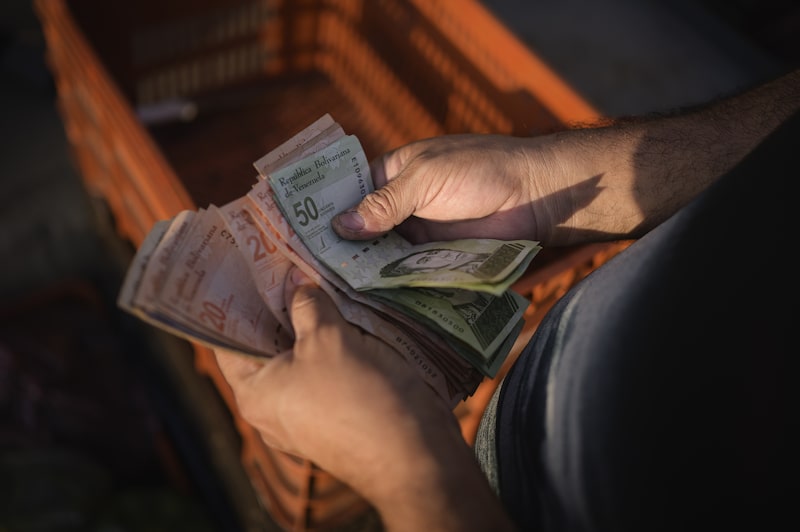 Un vendedor cuenta billetes de bolívar en un mercado de Caracas, Venezuela. Un vendedor cuenta billetes de bolívar en un mercado de Caracas, Venezuela.