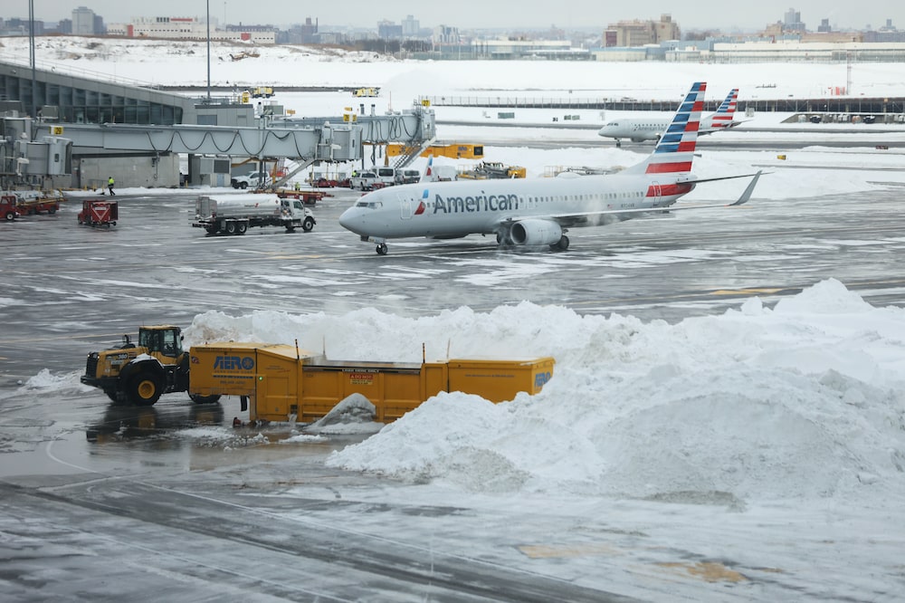 Un avión de American Airlines detrás de montones de nieve en el aeropuerto LaGuardia (LGA) en el distrito de Queens, Nueva York, EE.UU., el lunes 26 de enero de 2026. Un avión de American Airlines detrás de montones de nieve en el aeropuerto LaGuardia (LGA) en el distrito de Queens, Nueva York, EE.UU., el lunes 26 de enero de 2026.