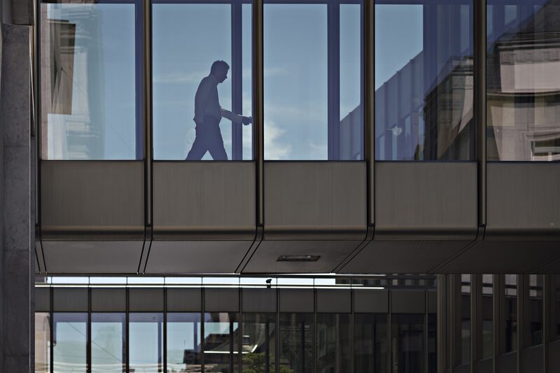 A worker walks across a bridge inside a UBS Group AG office building in Zurich, Switzerland. A worker walks across a bridge inside a UBS Group AG office building in Zurich, Switzerland.