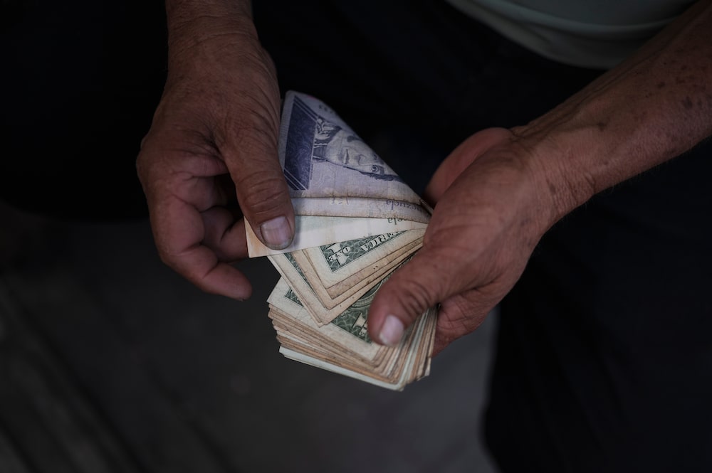 Un vendedor cuenta billetes de dólares estadounidenses y bolívares venezolanos en un mercado mayorista en Caracas, Venezuela, el miércoles 17 de diciembre de 2025. Un vendedor cuenta billetes de dólares estadounidenses y bolívares venezolanos en un mercado mayorista en Caracas, Venezuela, el miércoles 17 de diciembre de 2025.