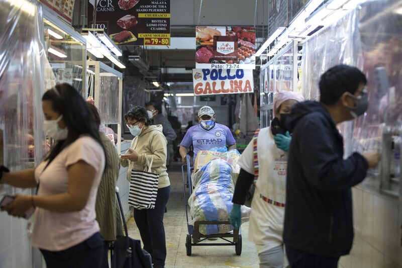 Los compradores compran carne de un carnicero en un mercado en Lima, Perú. Los compradores compran carne de un carnicero en un mercado en Lima, Perú.